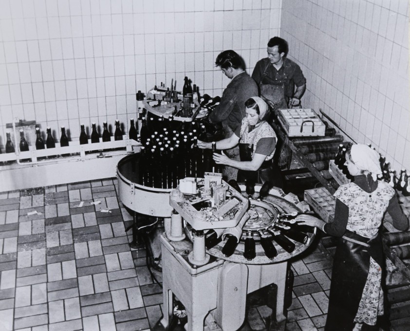 Eine Aufnahme aus dem Jahr 1952 zeigt Mitarbeiter der Brauerei bei der Ettikettierung der Bierflaschen.